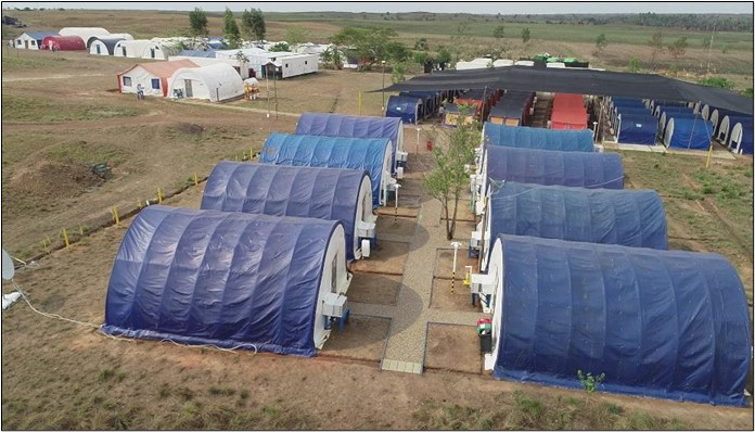 Campamento operativo al amanecer con decenas de técnicos preparándose